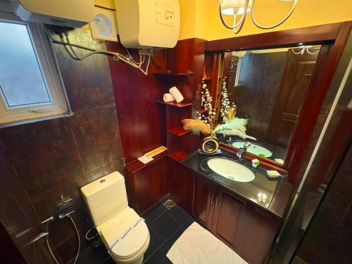 a bathroom with a toilet and a sink and a mirror at The Tapherini Bungalow in Nuwara Eliya