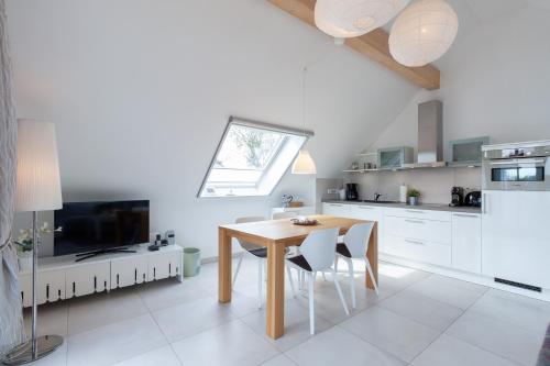 a kitchen with a dining room table and a window at Am Horizont No 2 für 2-4 Pers, 2 Schlafz, Babybett, Südbalkon, kostenloser Parkplatz 400 Meter zum Strand in Zingst