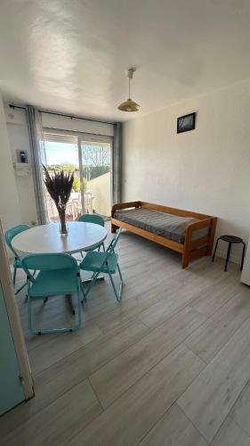 une pièce avec une table, des chaises et un lit dans l'établissement Les terrasses de la piscine, à Agde