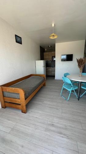 - une chambre avec un lit, une table et un réfrigérateur dans l'établissement Les terrasses de la piscine, à Agde