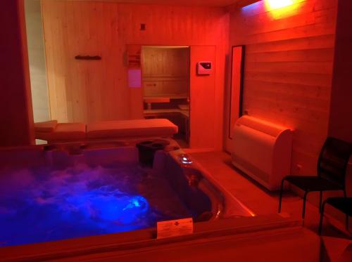 - un bain à remous dans une chambre avec des lumières rouges dans l'établissement moulin de la ribeyre, à Saint-Vincent