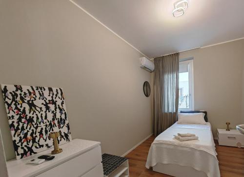 a white bedroom with a bed and a window at Alloggi Tosca Airport Lodges in Ronchi dei Legionari