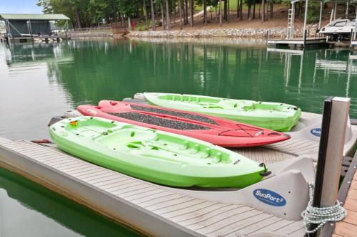 three boats sitting on a dock in the water at Lakefront Keowee Home with Dock, 14 Mi to Clemson in Seneca