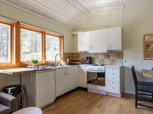 a kitchen with white cabinets and a table at Holiday Home Hölick Tallen 1 by Interhome in Hudiksvall
