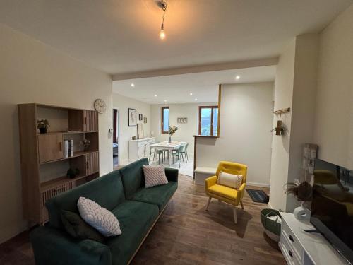 - un salon avec un canapé vert et un fauteuil jaune dans l'établissement #Brive - Villa Pagnon - Jardin -Calme, à Brive-la-Gaillarde