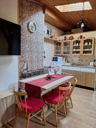 a kitchen with a table with red cushioned chairs at Chata Mária in Bojná