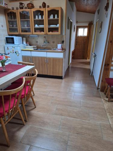 a kitchen with a wooden floor and a table and chairs at Chata Mária in Bojná