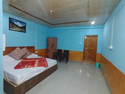 a bedroom with a bed and a blue wall at Exotica The Himalayan Ark in Sainj