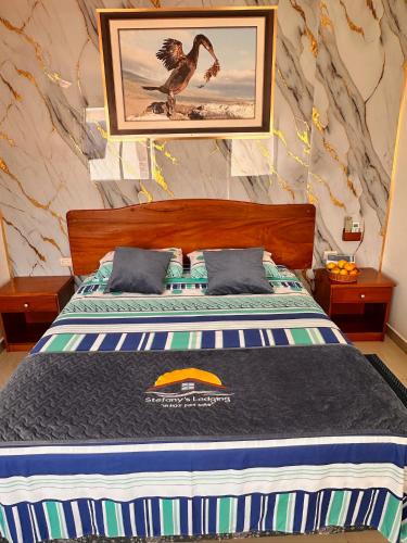 a bed with a picture of a bird on the wall at Stefany's Lodging in Puerto Baquerizo Moreno