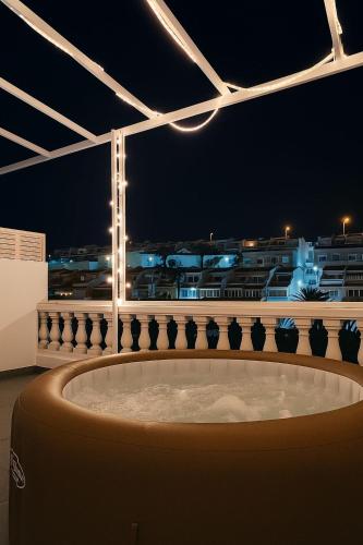 a large tub in a room with a city at night at Casa céntrica a estrenar in Adeje