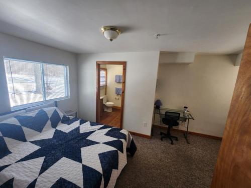 a bedroom with a bed and a desk and a window at Whispering Pines #4 in Calumet