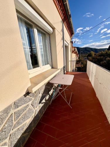 un banc sur le balcon d'une maison dans l'établissement Appartement avec garage le boulou pour cures ou vacances, au Boulou