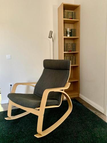 a chair sitting in a room with a book shelf at Quattro Casa in Sopron