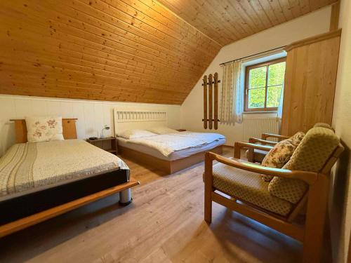 sypialnia z 2 łóżkami i krzesłem w pokoju w obiekcie Apartment in Pec pod Snezkou 2098 w mieście Velká Úpa