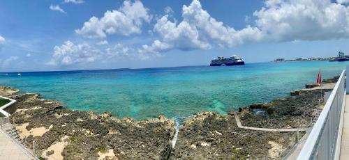 a cruise ship in the ocean near a beach at NEW Oceanfront Condo in George Town in George Town