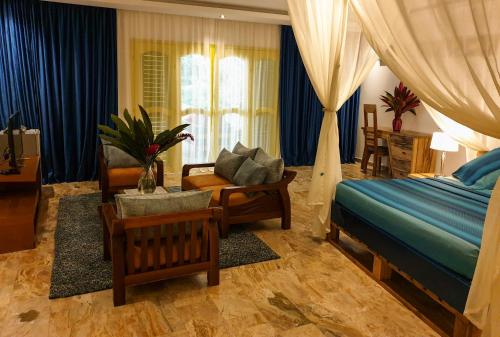 a bedroom with a bed and a couch and a chair at Villa Oasis Abidjan in Abidjan