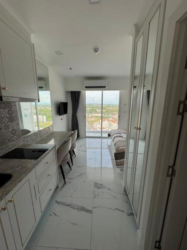 a kitchen with white cabinets and a large window at The Empire Tower Pattaya in Jomtien Beach