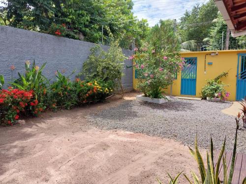 a garden with flowers and a yellow building at Recanto da Vovó - 3 Quartos in Santarém