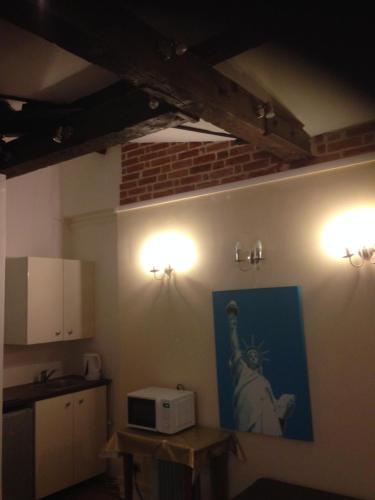 une cuisine équipée d'un four micro-ondes et d'une peinture murale. dans l'établissement Studio ETOILE TERNES PAR MONCEAU, à Paris