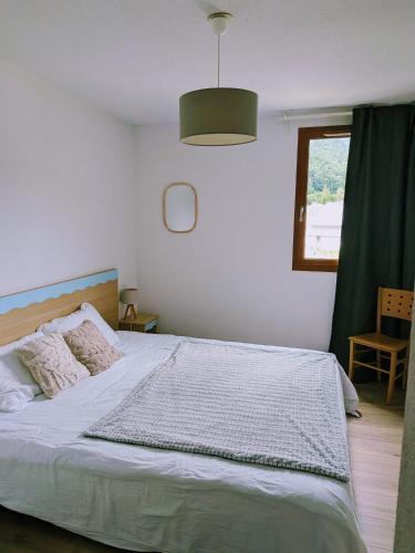 une chambre avec un grand lit blanc avec une fenêtre dans l'établissement Les Balcons de La Neste - Appt 5-6 pers, Balcon et Vue Montagne, à Arreau