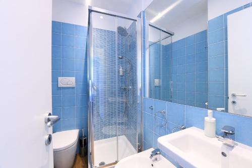 baño de azulejos azules con ducha y aseo en La Culla sul Mare centro storico, en Amalfi