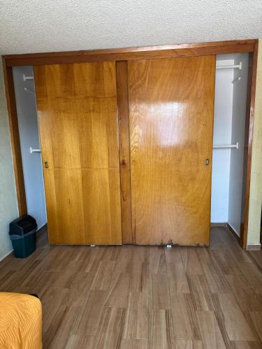 a room with two wooden doors and a hard wood floor at Casa Xochimilco in Mexico City