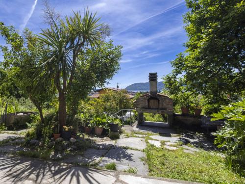 a garden with a house with a palm tree at Holiday Home Ornella by Interhome in Pallanza