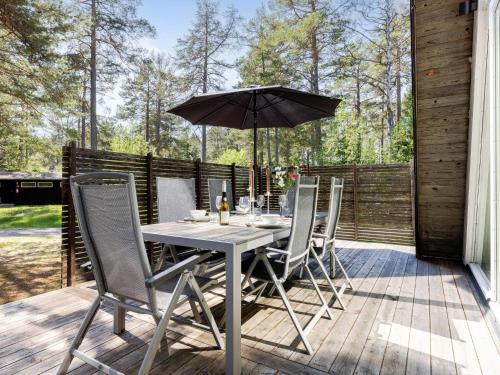 a table and chairs with an umbrella on a deck at Holiday Home Lagunen Villa 1 by Interhome in Hudiksvall