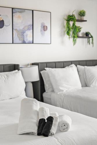 two beds with towels on top of them in a bedroom at Furnished Apartment in Brookline