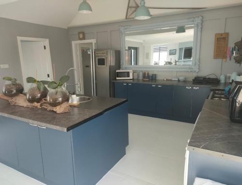 Country Cottage, Stunning Views في ترالي: مطبخ مع دواليب زرقاء وقمة كونتر