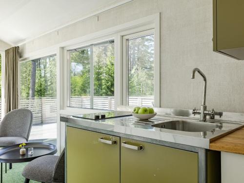a kitchen with a sink and a large window at Holiday Home Hölick Minichalet Plus 7 by Interhome in Hudiksvall