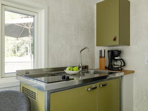 a kitchen with a sink and a bowl of apples at Holiday Home Hölick Minichalet Plus 7 by Interhome in Hudiksvall