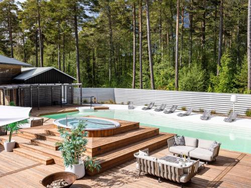 a patio with a swimming pool and a wooden deck at Holiday Home Hölick Minichalet Plus 7 by Interhome in Hudiksvall
