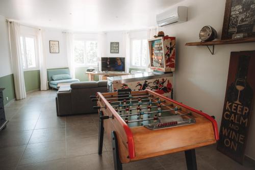 a living room with a foos ball on a table at Villa les trois pins in Venelles