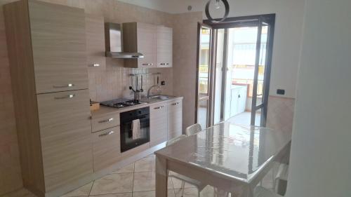 a kitchen with a glass table and a stove at dolce dimora in Pagani