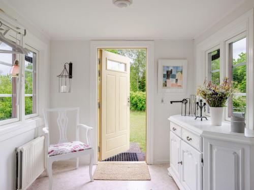 a white kitchen with a door leading to a yard at Holiday Home Bygget by Interhome in Simlångsdalen