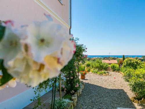 Elle offre une vue sur un jardin orné de fleurs sur un mur. dans l'établissement Holiday Home delle Rose by Interhome, à Livourne