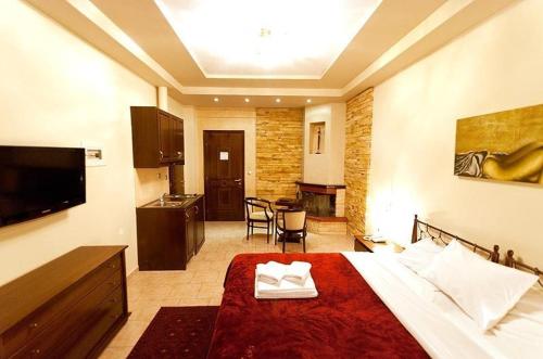 a hotel room with a bed and a kitchen at Nostos Hotel in Kato Loutraki