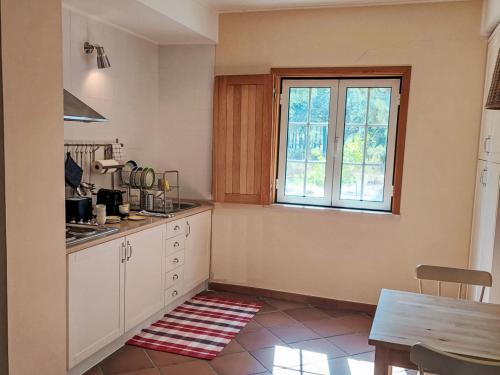 a kitchen with a table and a large window at Holiday Home Villa Alecrim by Interhome in Comporta