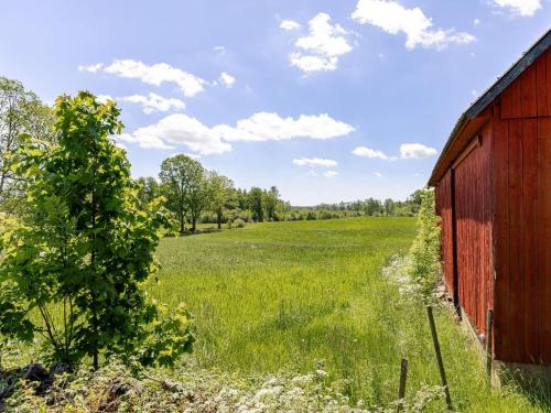 an old red barn in a field with a tree at Holiday Home Vetlycke by Interhome in Torsås