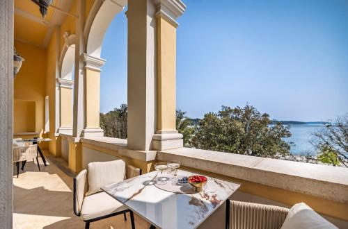 a table and chairs on a balcony with a view of the ocean at Boutique Hotel Mauro in Poreč