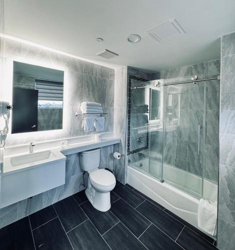 a bathroom with a toilet sink and a shower at Capital Hotel Long Island City in Queens