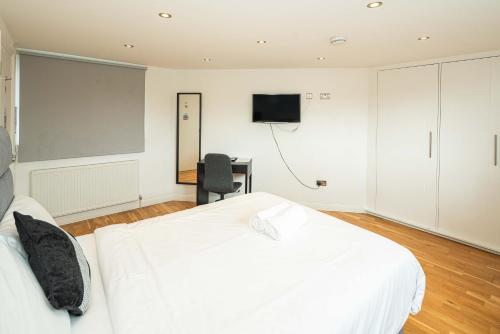a bedroom with a bed and a desk and a television at SE10 House in London