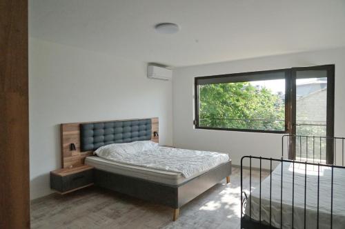 a bedroom with a bed and a window at Six bedroom luxury villa with private pool in quiet residential area near beaches in Sozopol