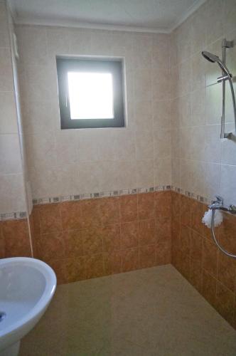 a bathroom with a sink and a toilet and a window at Six bedroom luxury villa with private pool in quiet residential area near beaches in Sozopol