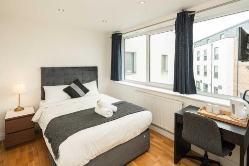 a bedroom with a bed with a desk and a window at SE10 House in London