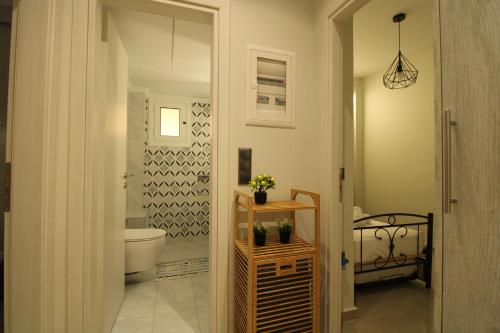 a bathroom with a toilet and a sink in a room at Oropos Central Living in Néa Palátia