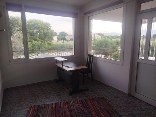 a room with a desk and two windows with a view at Welcoming apartment in Tríkala