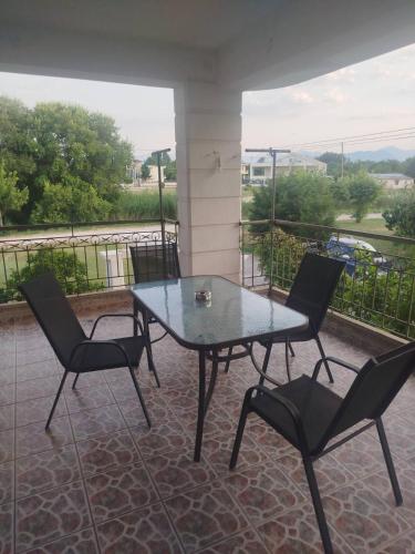 a glass table and chairs on a patio with a view at Welcoming apartment in Tríkala