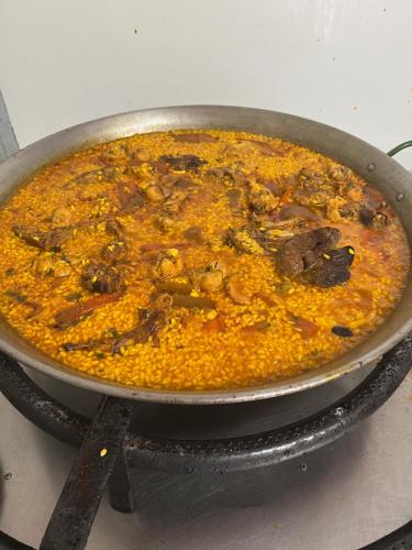 a pan full of food on a stove at Hotel Mesón del Moro in Abarán